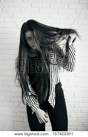 Portrait of young laughing woman. Expressive portrait of beautiful young brunette woman.  Hair is covering half of her face