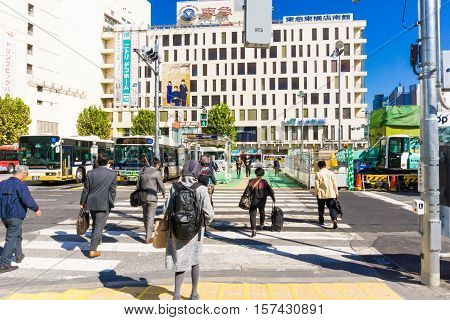 TOKYO JAPAN - OCTOBER 24 2016: Unidentified People Walk at Shibuya Crossing in Tokyo. on October 242016. It has an estimated population of 221801 and a population density of 14679.09 people per sqkm