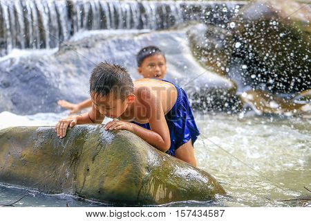 Penampang,Sabah-Oct 29,2016:Kids enjoying and having fun with waterfall in Babagon river,Penampang,Sabah on 29th Oct 2016.