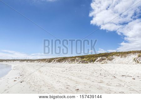 Water Washing Up On The White Sand With A View Of An Island; Galapagos