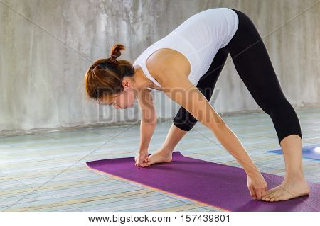 Young woman practicing yoga in a urban background