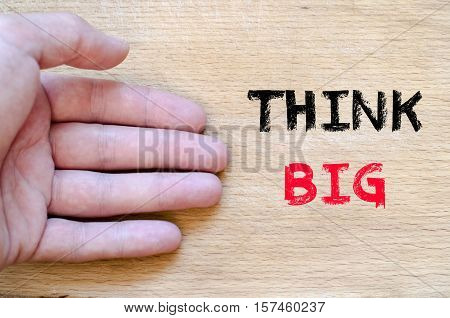 Human hand over wooden background and think big text concept