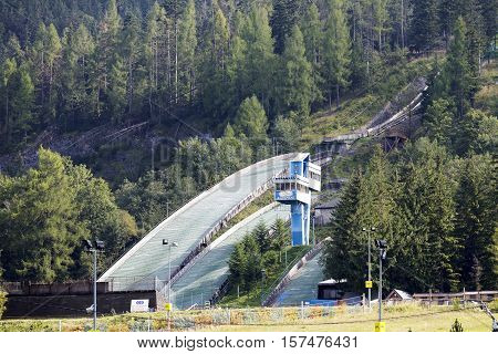 ZAKOPANE POLAND - SEPTEMBER 12 2016: Ski Jumps Complex which can be seen among the trees was built in 1950 it is built directly on a mountain