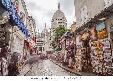 PARIS FRANCE - 28TH JULY 2016: A view along streets in Montmartre Paris during the day. The Sacre-Coer can be seen in the distance