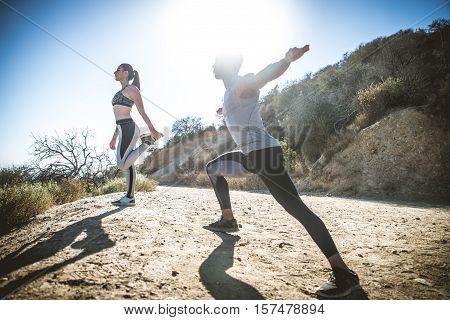 Couple of joggers doing stretching before starting to run