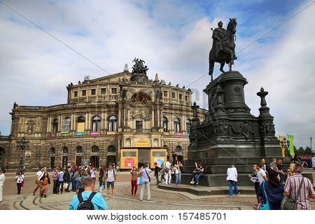DRESDEN GERMANY - AUGUST 13 2016: Tourists walk and visit on Semperoper opera (Staatskapelle Dresden) at Theaterplatz building was designed by Gottfried Semper in Dresden Germany on August 13 2016.