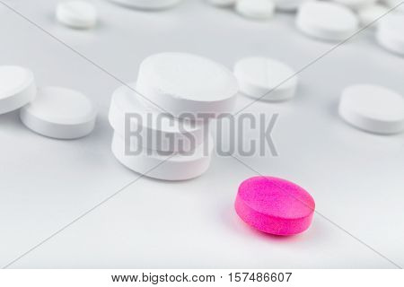 Bunch Of White Tablets. Scattered Pills. Single Pink Pill