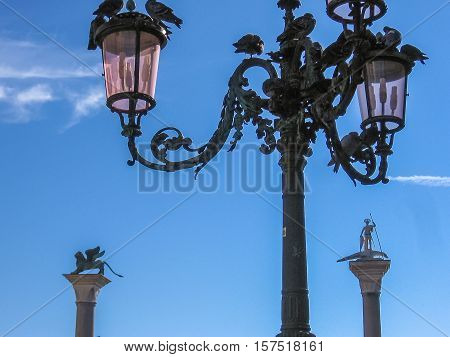 Details of Venice. San Marco square in Venice with San Marco lion statue and its famous street lamp close up.