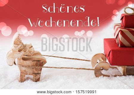 Moose Is Drawing A Sled With Red Gifts Or Presents In Snow. Christmas Card For Seasons Greetings. Red Christmassy Background With Bokeh Effect. German Text Frohe Weihnachten Means Merry Christmas