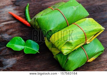 Sour pork Thai northeastern style food which mixed pork rice garlic sugar and salt in banana leaf package.