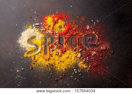 Word Spice drawing on various spices on stone table. Top view