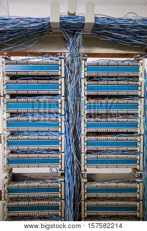 Color image of an old telephone exchange wit many wires.