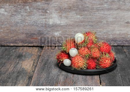 rambutan sweet fruit fresh in plate on wood background :Select focus with shallow depth of field.