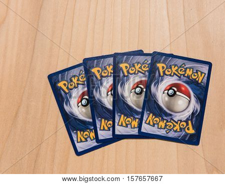 New York City, NY, USA - July 12, 2016: Four Pokemon trading cards in a row on a wooden surface. Illustrative Editorial