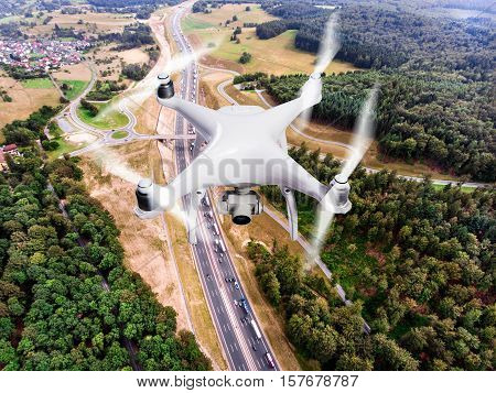 Hovering drone taking pictures of highway junction in the middle of green forest, traffic jam, Netherlands. Aerial view.
