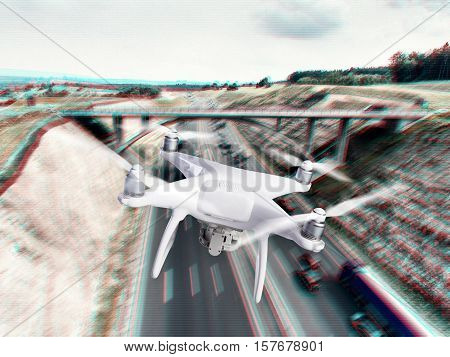 Hovering drone taking pictures of highway with cars and trucks, bridge and nature of Netherlands. Aerial view.