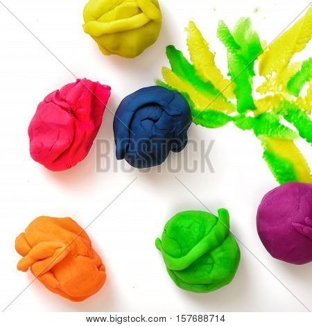 Several balls of multicolored plasticine on the white background. Art and creativity. Kid's games and activities. Handmade objects.