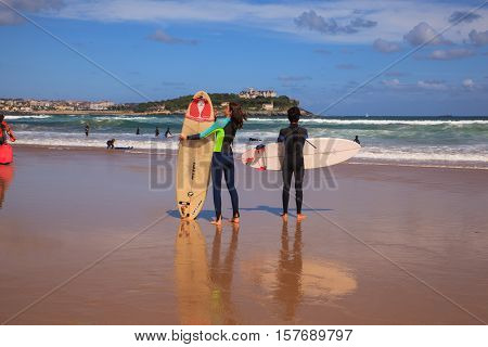 SANTANDER SPAIN - AUGUST 20: Surfer couple carrying their surfboard on the beach on August 20 2016