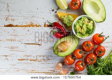 Guacamole sauce and indredients on wood background, copy space