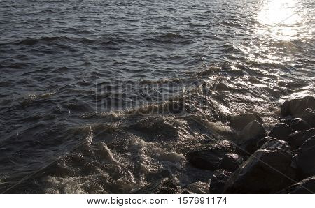Lumpy sea and rocks on sunset. Lumpy sea at cloudy day