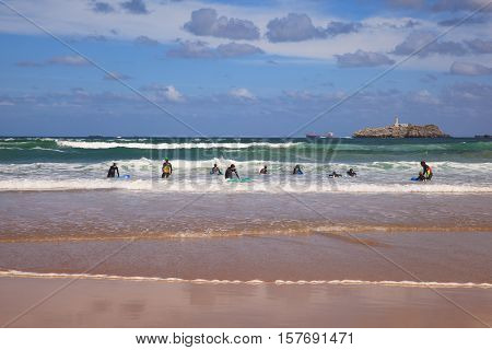 SANTANDER SPAIN - AUGUST 20: Boys teen surfing in Cantabrian sea on August 20 2016