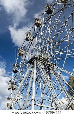 Ferris wheel against the background of the blue sky in the autumn park