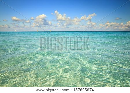 Clear water of Atlantic ocaen resort. Three sail catamarans are on horizon.