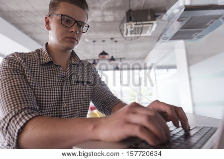 young businessman with glasses at  startup business office space working on modern  laptop  computer