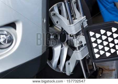 Checking process. Close up of car tyre clamped in alignment machine device while being checked