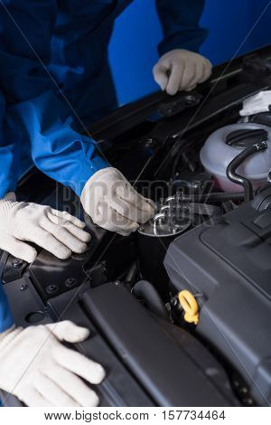 Check it correctly. Close up of car engine while professional mechanics checking and repairing it
