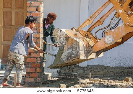 Labuan,Malaysia-April 7,2016:Construction site workers during concrete pouring into formwork at housing area at Labuan,Malaysia on 7th April 2016.