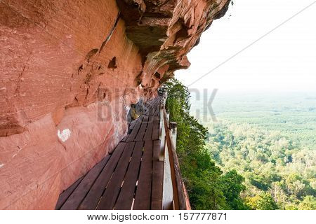 Beautiful Wooden bridge in red cliffside at Wat Phu tok mountain. Bueng Kan Thailand