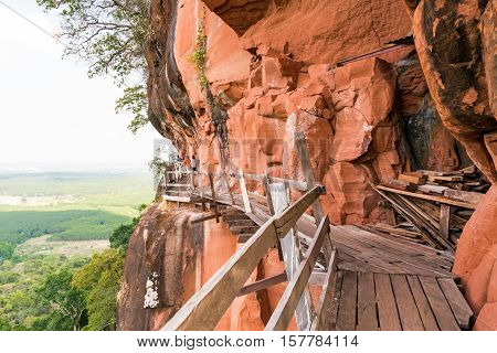 Beautiful Wooden bridge in red cliffside at Wat Phu tok mountain. Bueng Kan Thailand