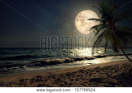 Beautiful fantasy tropical beach with Milky Way star in night skies full moon - Retro style artwork with vintage color tone (Elements of this moon image furnished by NASA)