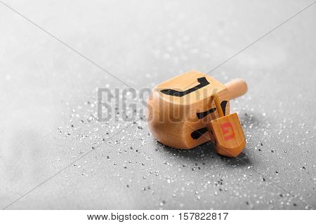 Wooden dreidels for Hanukkah on light background