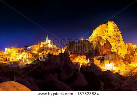 Night Scene Of The Uchisar Castle In Cappadocia. Illuminated View Of Famous Uchisar Village, Distric