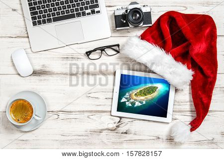 Business Holidays Concept. Office Workplace with Coffee and Christmas Decoration. Tropical island picture
