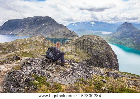Young man hiking on Besseggen. Happy man enjoy lake and good weather in Norway