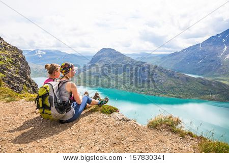 Young woman hiking on Besseggen. Happy girl enjoy lake and good weather in Norway.