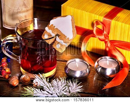 Warming drink decorate cookie. Label on bottle of wine and gift box. Warming grog with wine and cookie in form of house on brick wall.