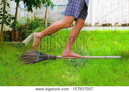 Standing on a broom floating on grass