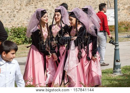 TELAVI, GEORGIA - SEP 30, 2016: Happy young Georgian girls in vintage dresses with veils emotionaly talking during festival TelaVino on 30 September, 2016. Telavi of Kakhetia has population 22000