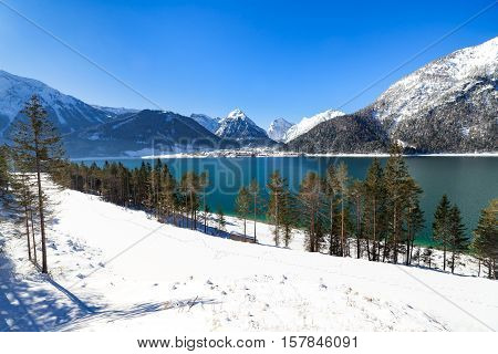 Idyllic snow landscape with mountain lake Achenlake Achensee Austria Tirol.