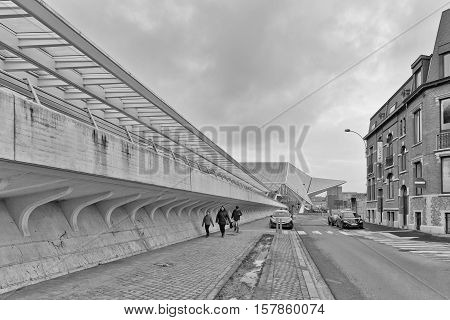 LIEGE BELGIUM - December 2014: Traveller walking in front of the Liege-Guillemins railway station designed by Santiago Calatrava. Black and white photograph
