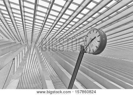LIEGE BELGIUM - December 2014: Abstract view on the roof with station clock of the Liege-Guillemins railway station designed by Santiago Calatrava. Black and white photograph