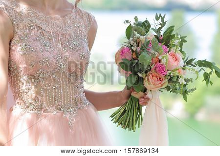 Beautiful bridal bouquet in hands of the bride. Wedding bouquet of peach roses  single-head pink rose aqua eucalyptus ruscus gypsophila
