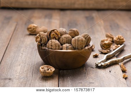 Walnuts in wooden bowl on table with Nutcracker.