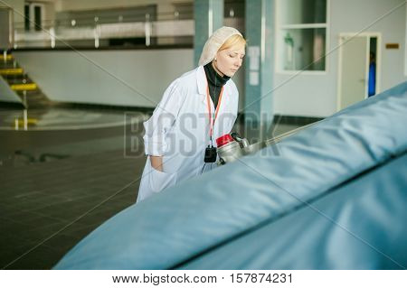 On The Territory Of Brewer's Plant With Steel Fermentation Vats. Female Employee Performs Process Co