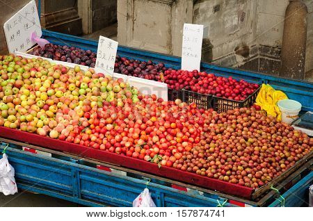 Fresh plums nectarines and apples for sale on the back of a truck in Puxi side of Shanghai China.