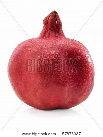 Ripe red pomegranate with water drops on a peel on a white background isolated